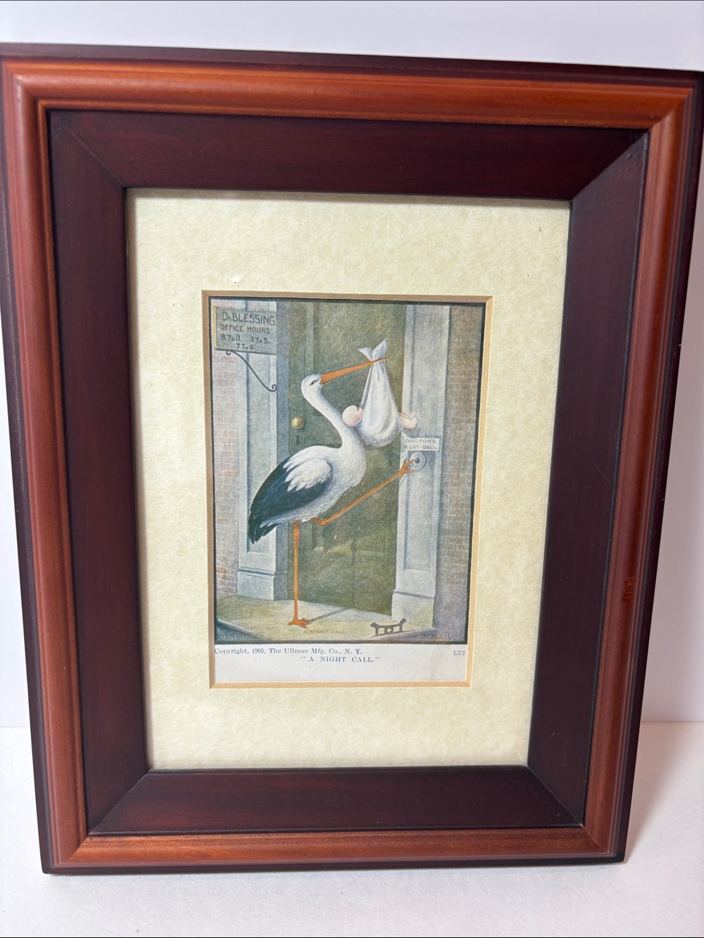 Framed Vintage postcard from 1905. Shows stork delivering a baby.